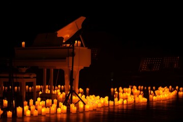 Grand piano in a concert hall in lite of candles