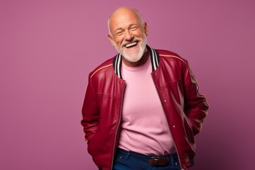 Fototapeta premium Portrait of a happy man in his 60s sporting a stylish varsity jacket isolated in solid color backdrop