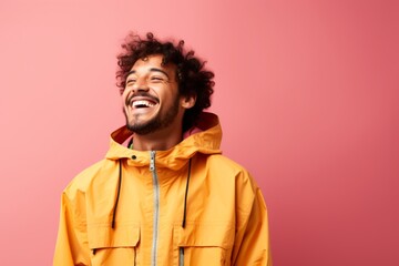 Fototapeta premium Portrait of a joyful man in his 20s wearing a lightweight packable anorak isolated on solid color backdrop