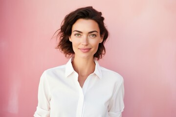Fototapeta premium Portrait of a content woman in her 30s wearing a simple cotton shirt on solid pastel color wall