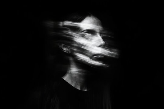 Woman suffering from depression and anxiety in blurred motion black and white portrait