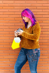 Body positive autistic girl with pink hair using a vintage camera