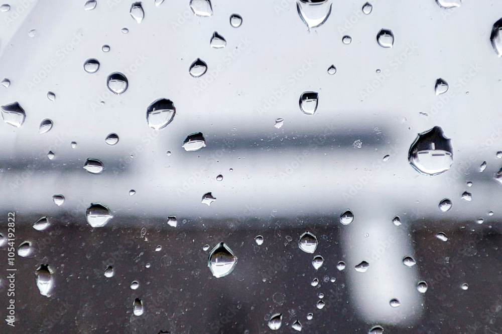 Poster raindrops on a window create a beautiful abstract pattern, highlighting the beauty of nature's eleme