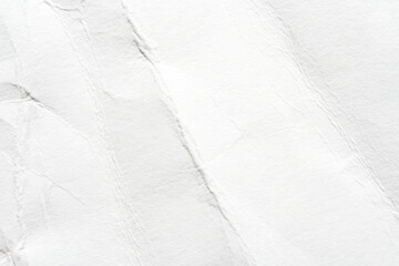 Close-up of white textured paper with wrinkles and creases for backgrounds and creative designs.
