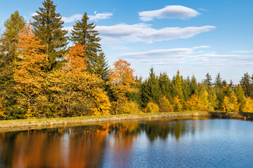 Autumn landscape with beautiful colorful trees reflected in the lake. Beskydy Mountains in Czech Republic, Europe.