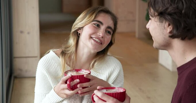 Smiling couple enjoying hot cocoa together at home during Christmas season