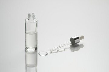pipette mit hyaloron flasche, tropfen auf  spieglenden  hintergrund 