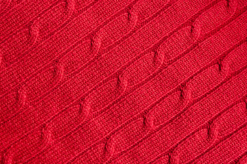 Red sweater texture as winter background. Selective focus, copy space