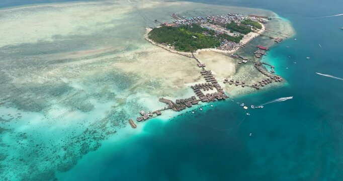 Aerial view of tropical island Mabul in the blue sea with a coral reef and the beach. Semporna, Sabah, Malaysia.