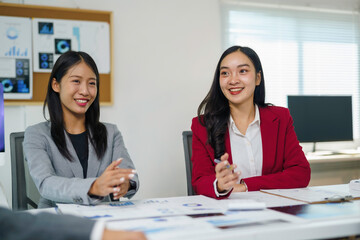 Fototapeta premium Asian businesswomen discussing business strategy during a corporate meeting in a modern office