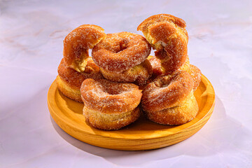 Stack of Homemade Sugar-Coated Donutson a Wooden Plate