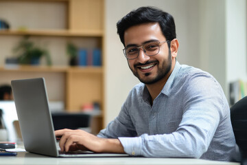 Fototapeta premium smiling man working on laptop in modern office environment, showcasing professional and friendly atmosphere