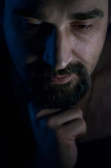 Depressed Man with Beard in Dark Room. Problems, Anxiety, Sadness Concept.