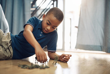 Boy, soldiers and playing with action figures on floor for fun entertainment or childhood at home....