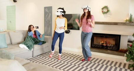 Women friends enjoying virtual reality games at home during Christmas celebration - Powered by Adobe