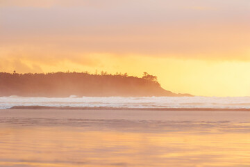 Obraz premium Ocean landscape in sunset light with waves, rocks and trees.