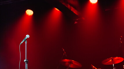 Background - microphone on stage against red spotlights, no people