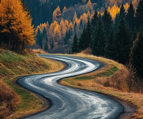 Naklejka premium Winding road through autumn forest with vibrant foliage in the hills