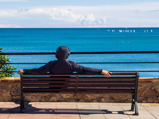 Hombre joven con auriculares mirando al mar en Benalmádena, España