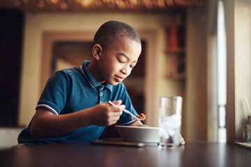 African kid, boy or eating food in home for nutrition, hungry or healthy development at table....