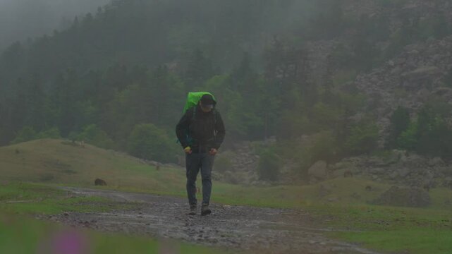 Chico andando en la monta&ntilde;a con mochila y gorra
