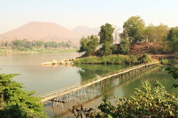 View from the old town on a traditional bamboo bridge over the Nam Khan River, the Mekong River in the background, Luang Prabang, Laos