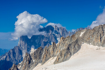 Snow covered mountains and rocky peaks of the Alps from the sky way between Chamonix and Courmayeur in Italy and France Alps. Dent du Gigante rocky towering peak and glacier at the bottom of Montblanc