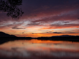 Landscape of a lake with the reflection of the mountains and clouds at autumn sunset in Granada (Spain)