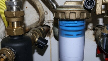 Insulated piping in the foreground Home heating system pipe with shut-off valve and pipes in north Italy.