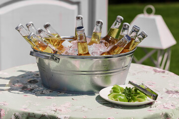 Refreshing Summer Gathering with Bottled Beverages in Ice Bucket