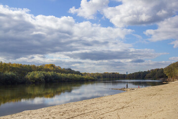 landscape sandy beach on the bank of the river Desna in Chernigov, dense forest behind the river