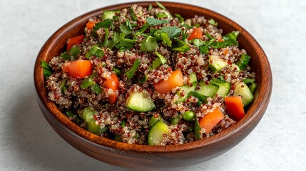 A close-up shot of a bowl of quinoa salad with tomatoes, cucumber, and cilantro.