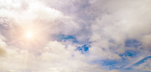 Blue sky with white clouds and bright sun.