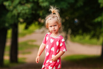 Portrait of a Caucasian child girl toddler outside in summer.