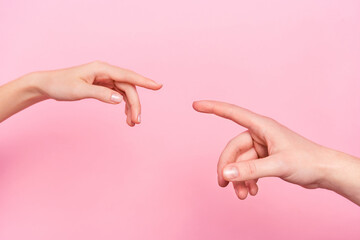 Cropped close up portrait of two arms fingers raise touch each other isolated on pink color...