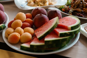 Fresh and Colorful Fruit Platter Featuring Watermelon, Peaches, and Apricots