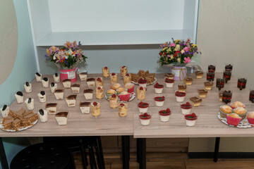 Delightful Dessert Table Featuring an Array of Sweet Treats and Floral Arrangements