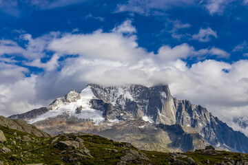 The Petit Dru mountain summit displays rugged peaks and rocky formations against clear sky. Rocky...