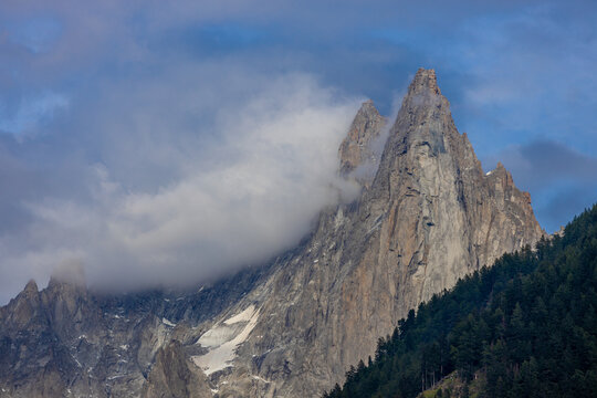 The Petit Dru mountain summit displays rugged peaks and rocky formations against clear sky. Rocky peak of Aiguilles de Dru, les Drus in Chamonix Alps