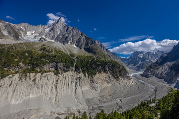 The Petit Dru mountain summit displays rugged peaks and rocky formations against clear sky. Rocky...
