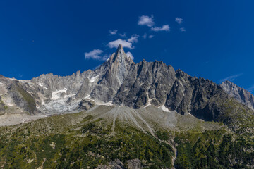 The Petit Dru mountain summit displays rugged peaks and rocky formations against clear sky. Rocky peak of Aiguilles de Dru, les Drus in Chamonix Alps