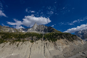 The Petit Dru mountain summit displays rugged peaks and rocky formations against clear sky. Rocky...