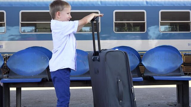 Child with large baggage arrives in the train station