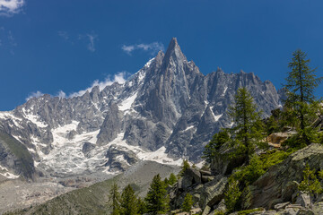 The Petit Dru mountain summit displays rugged peaks and rocky formations against clear sky. Rocky...