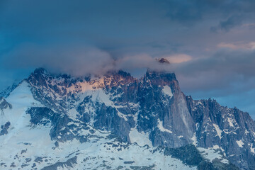 The Petit Dru mountain summit displays rugged peaks and rocky formations against clear sky. Rocky...