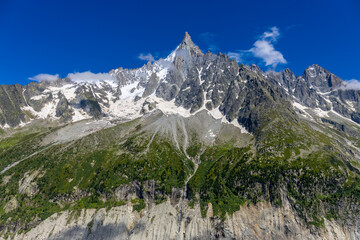 The Petit Dru mountain summit displays rugged peaks and rocky formations against clear sky. Rocky...