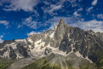 The Petit Dru mountain summit displays rugged peaks and rocky formations against clear sky. Rocky...