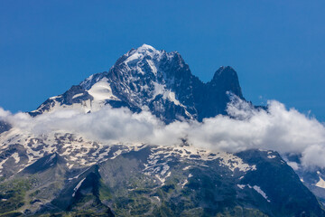 The Petit Dru mountain summit displays rugged peaks and rocky formations against clear sky. Rocky...