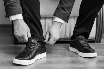 Man adjusting pants while wearing stylish black sneakers