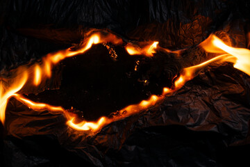 burning paper, glowing edge of paper on a black background